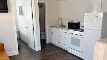 Een koelkast met diepvriezer, een microgolfoven, een oven, een kookplaat