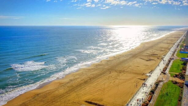 A beach with a long promenade, a clear sky, and the ocean. - Sojourn The Ocean Breeze in Virginia Beach (Virginia Beach)
