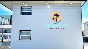 Ein Gebäude mit der Aufschrift "Brooklyn Beach Club" und einem Logo mit Palmen.