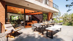 An outdoor patio with a dining table set for six, a sofa, and lounge chairs. - Casa Grande - Spectacular House in Avándaro (Valle de Bravo)