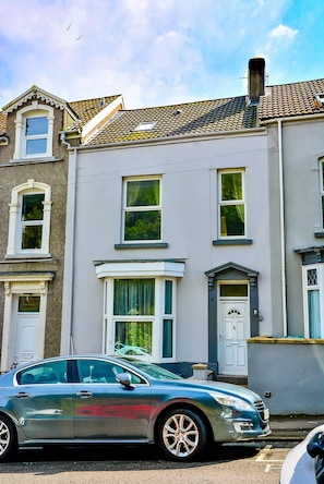A row of townhouses with a car parked in front.