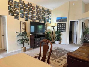 Relax in a stylish living room with a flat-screen TV, comfortable sofa, and a variety of artwork.