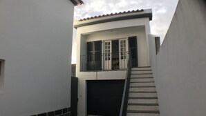 A residential building with a staircase leading to a garage.