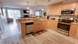 Una cocina moderna con armarios de madera, electrodomésticos de acero inoxidable y una isla central.