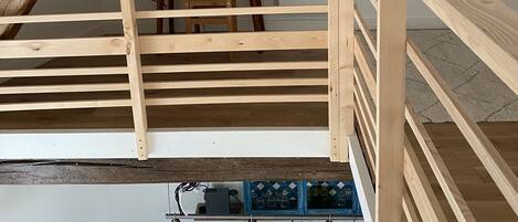 A wooden staircase with a handrail, a table, and a lamp on the landing.