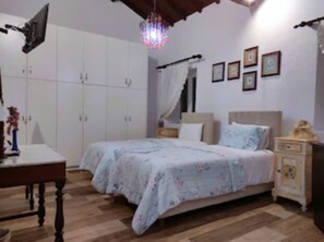 Quarto com cama, mesa de cabeceira, guarda-roupa e um candelabro.