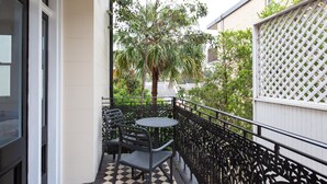 A balcony with a checkered floor, a round table, and four chairs. - Intimate Studio Apartment with Balcony in Glebe (Glebe)