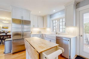 Prepare meals in a well-lit kitchen with ample counter space and a large island.