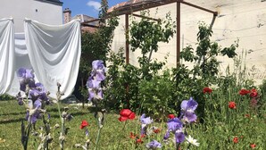 A garden with various flowers and a pergola structure. - Charming mezzanine studio (La Chapelle-Saint-Mesmin)