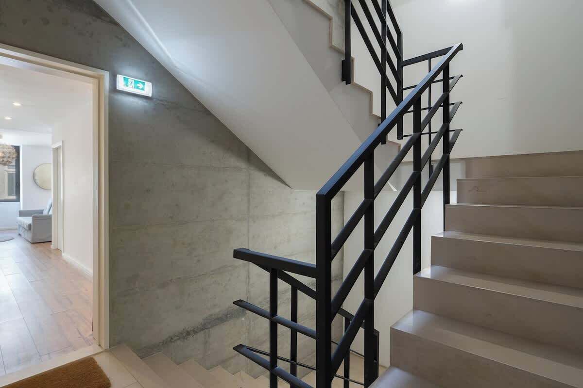 A staircase with black railings leading to a landing.