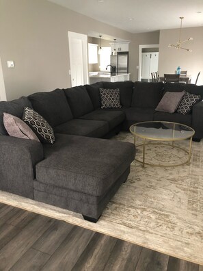 Relax in this stylish living room with a comfortable sectional sofa and a dining area nearby.