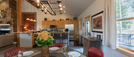 Enjoy meals in this cozy dining area with a fireplace, round table for four, and a view of the outdoors.