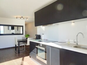 Enjoy cooking in this well-equipped kitchen with an oven, stainless steel sink, and dining area.