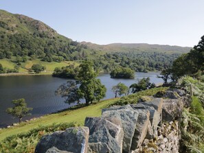 A stone wall with a view of a lake surrounded by hills and trees. - Howgills Retreat (Kendal)