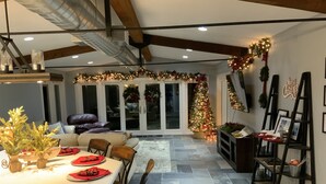 Cocina amplia con comedor, que incluye una isla grande, sillas y un árbol de Navidad.