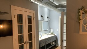 Un dormitorio con cama, cómoda, espejo y televisor.