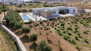 A modern villa with a swimming pool, stone walls, and a view of a mountain. - Bracket House Paros Villa with Private Pool Sleeps 8 (Paros)
