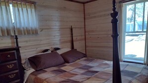 A bedroom with a wooden four-poster bed, a dresser, and a window with blinds. - Riverfront Property Great for Fishing or Just Relaxing (Hesperia)
