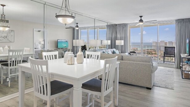 Ein modernes Wohnzimmer mit Essbereich, großen Fenstern und einem Balkon mit Blick.