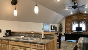 Una cocina con una isla grande, armarios de madera y un ventilador de techo.