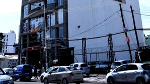 A multi-story hotel with a prominent 'Yellow Apple Hotel' sign, multiple balconies, and a 'Cal Burger' restaurant on the ground floor. - yellow apple hotel (Addis Ababa)