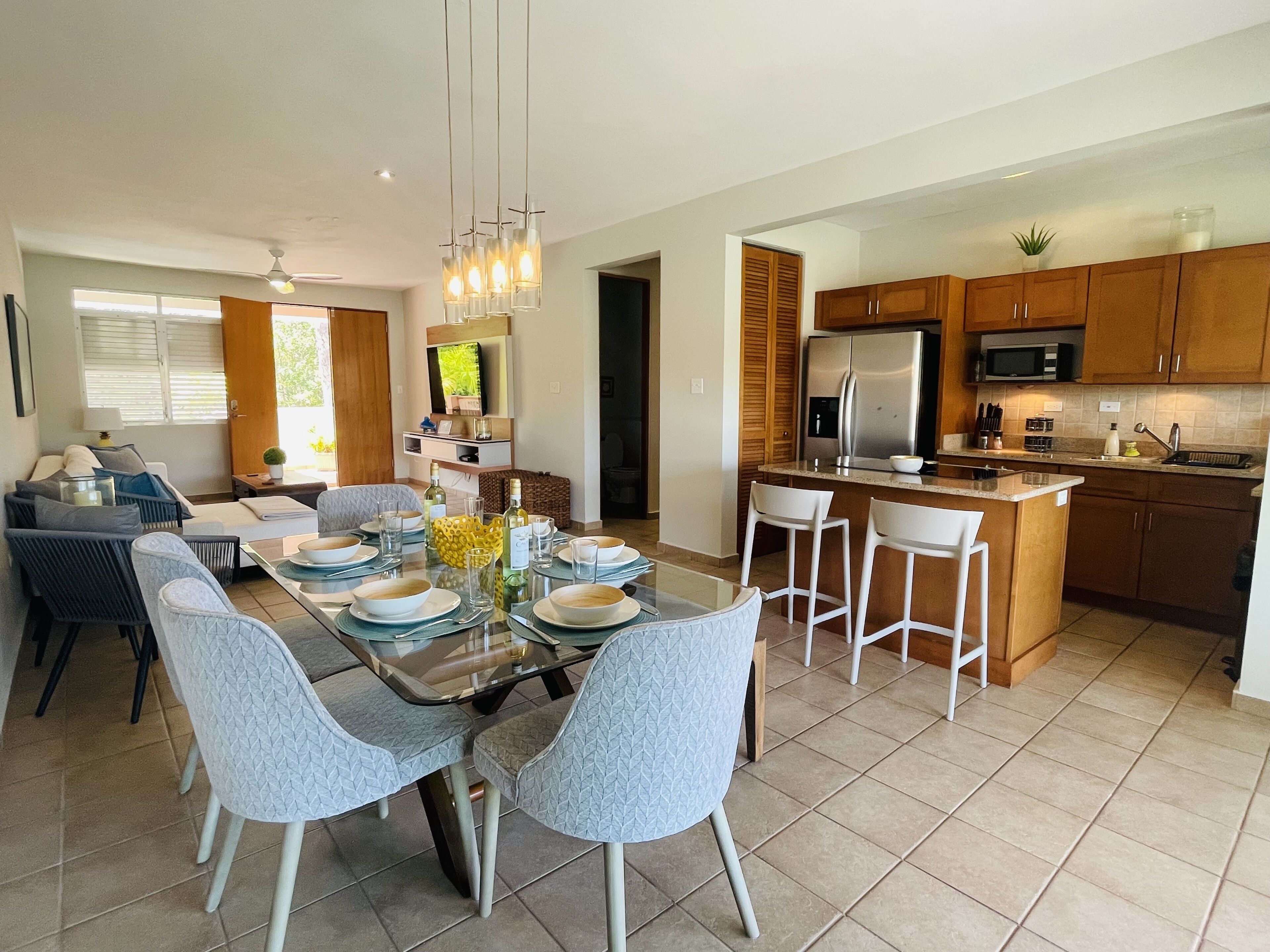 A modern kitchen with a central island, wooden cabinets, and a built-in microwave.