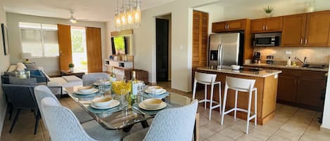 A modern kitchen with a central island, wooden cabinets, and a built-in microwave.