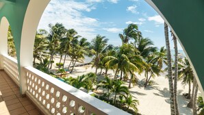 A balcony with a view of a beach, palm trees, and a clear sky. - 10% OFF ON STAYS OF 7 NIGHTS OR MORE ! AMAZING BEACHFRONT PROPERTY.. (San Pedro)