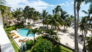 A resort with a pool, palm trees, and a beach area. - 10% OFF ON STAYS OF 7 NIGHTS OR MORE ! AMAZING BEACHFRONT PROPERTY.. (San Pedro)