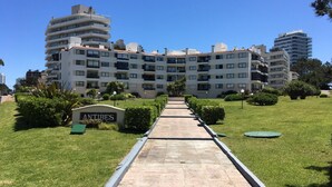 A multi-story residential building with a central courtyard, surrounded by well-maintained lawns and pathways.