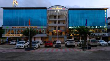 A hotel with a modern glass facade, multiple floors, and a prominent sign reading "SAI AVENUE HOTEL".