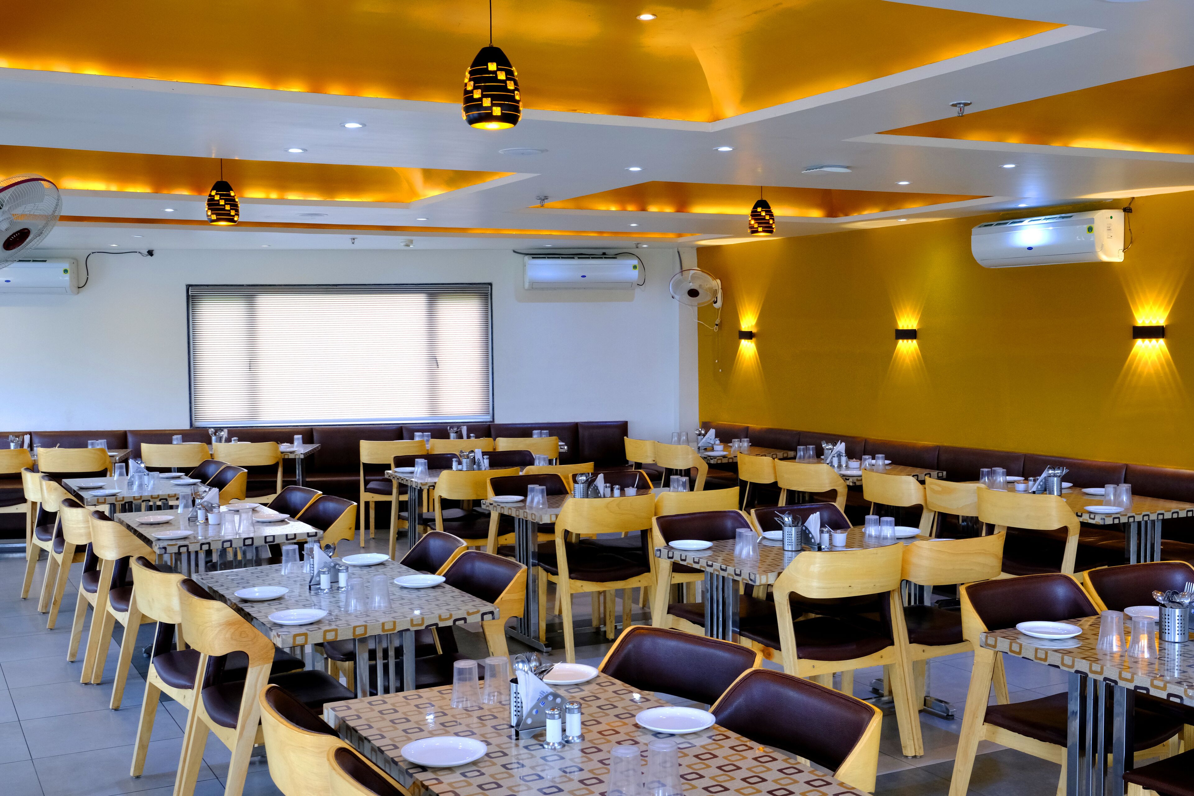 Um restaurante com várias mesas e cabines, equipado com cadeiras e utensílios de refeição.