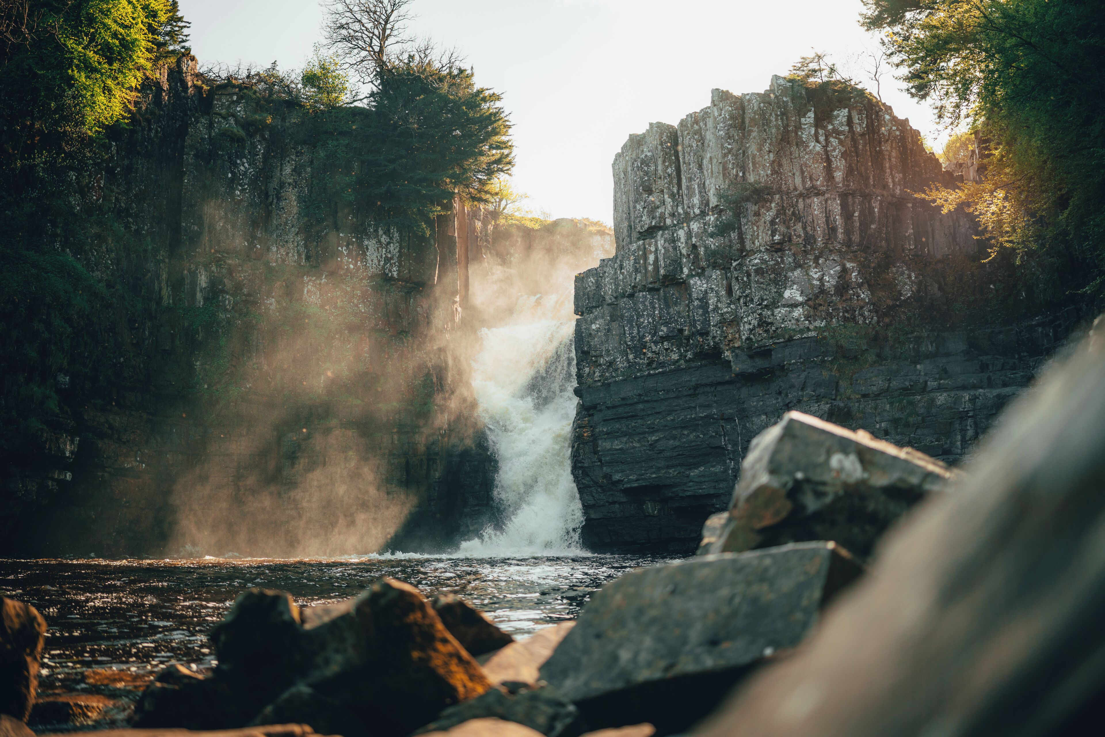 A waterfall surrounded by rocky terrain and dense foliage.