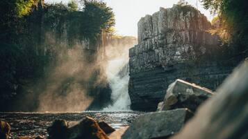 A waterfall surrounded by rocky terrain and dense foliage.