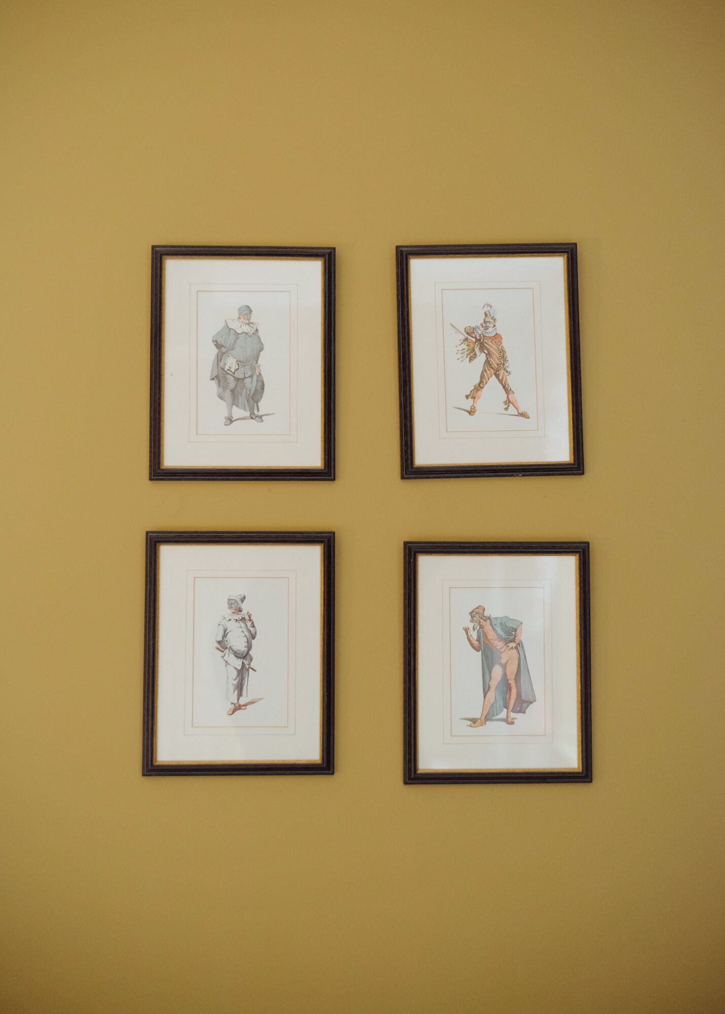 Four framed artworks on a wall.