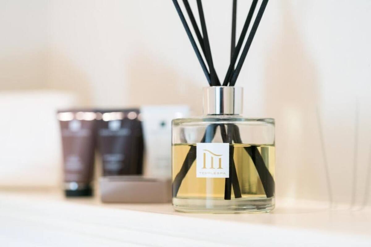 A bottle of perfume with a label, surrounded by other cosmetic products.