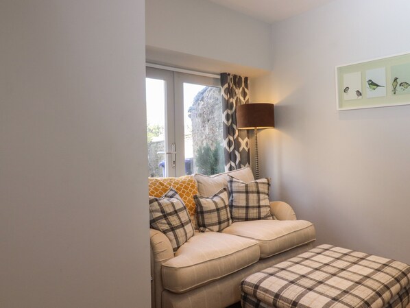 A living room with a sofa set, a lamp, and a wall with framed artwork.
