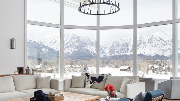 A spacious living room with a high ceiling, large windows, and a view of snow-capped mountains. - Sweeping Teton views, modern renovation. Minutes from town & National Parks. (Jackson)