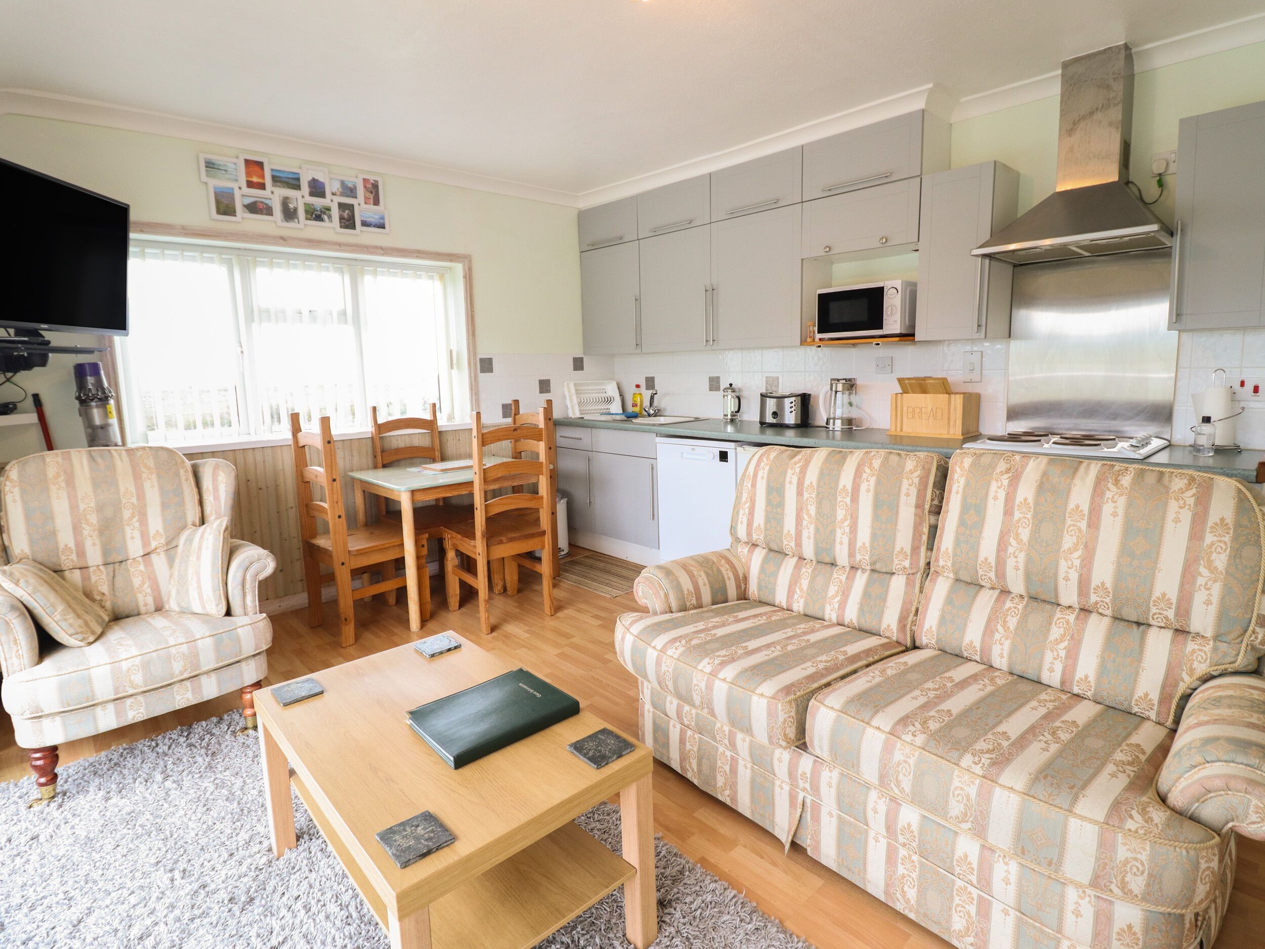 A compact living space with a dining area, sofa, and kitchenette.