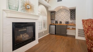 A modern kitchen with a fireplace, patterned backsplash, and a built-in oven. - Incredible home with custom pool and fountain (El Paso)