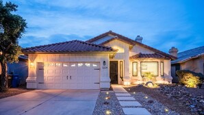 A two-story house with a garage, a covered entryway, and a well-maintained garden with stepping stones. - The White House, Heated Pool! PuttingGreen (Phoenix)