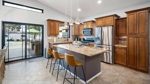 A modern kitchen with a large island, stainless steel appliances, and wooden cabinets. - The White House, Heated Pool! PuttingGreen (Phoenix)