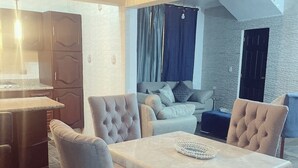 Een moderne woonruimte met een eethoek, keuken en zithoek met een bank en stoelen.