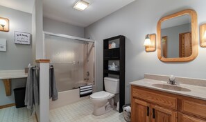 Een bad/douchecombinatie, een haardroger, handdoeken, zeep