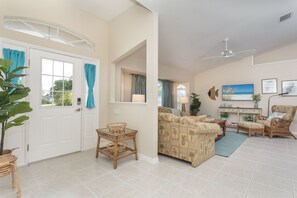 A spacious living area with a sofa, chairs, a table, and a ceiling fan. - Quaint SW Florida Getaway. Close to Boca Grande (Port Charlotte)