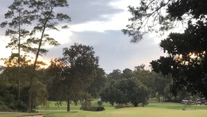 A golf course with sand bunkers, trees, and a clear sky. - Private Studio Retreat on the Golf Course (Conroe)