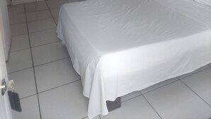 Un dormitorio con una litera, una cama individual y una ventana con cortina.
