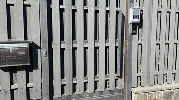 A metal gate with a keypad lock and a mailbox.