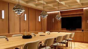 A conference room with a long table, multiple chairs, and three pendant lights. - Live and Stay - Ekmanska (Gothenburg)