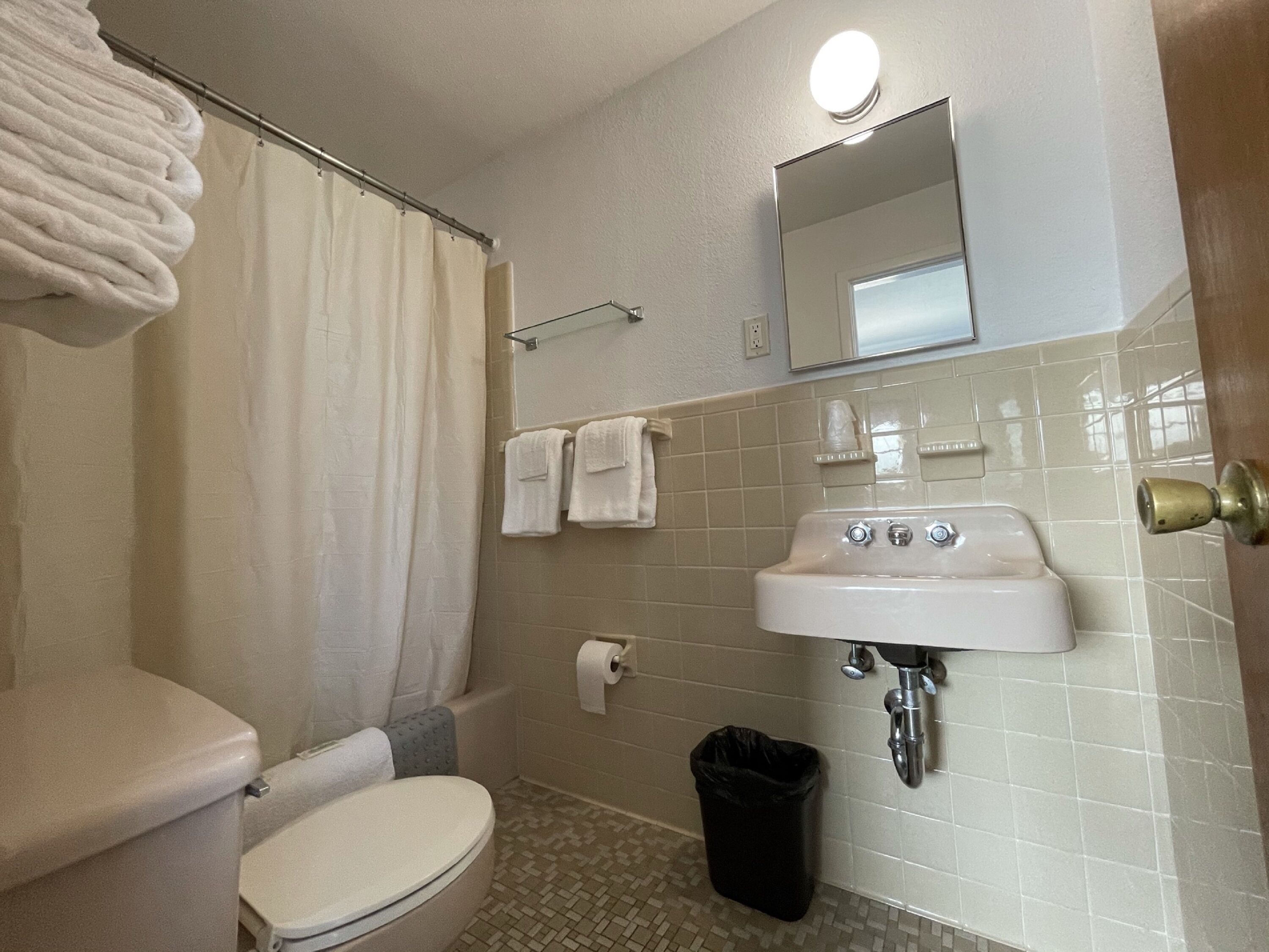 A bathroom with a toilet, sink, and shower curtain.